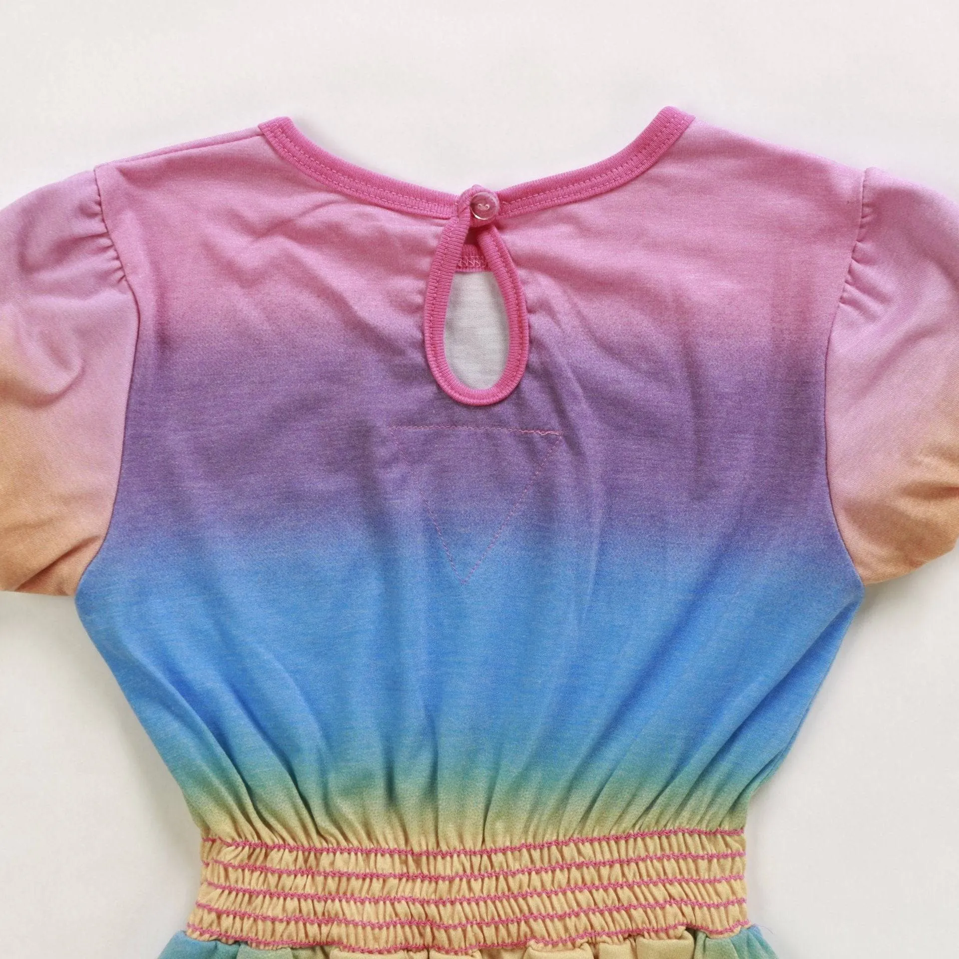 Close-up of the rainbow dress back showing the keyhole opening and button closure