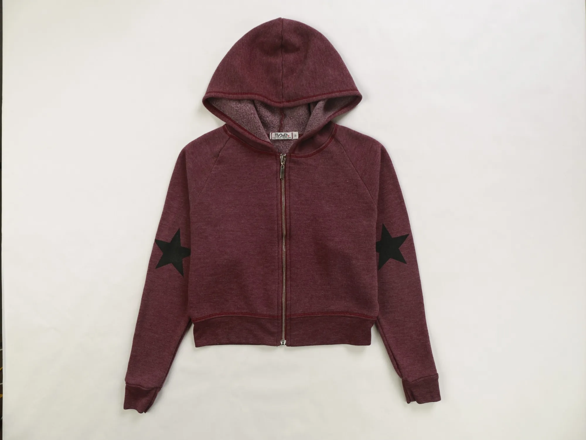 Burgundy zip-front hoodie with black star prints on both sleeves, laid flat on white paper