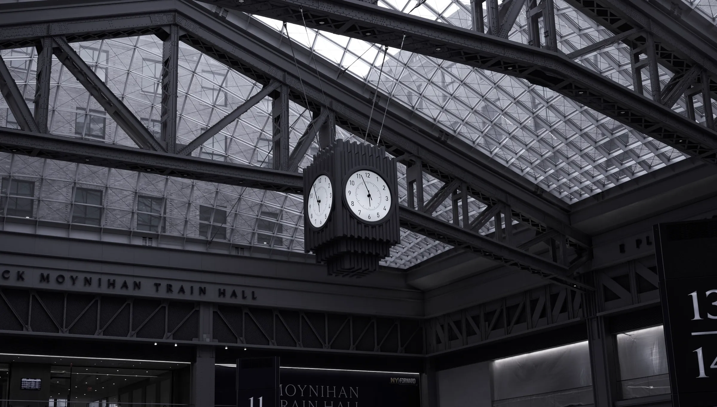 Black-and-white view of the Moynihan Train Hall skylight and central clock, New York City