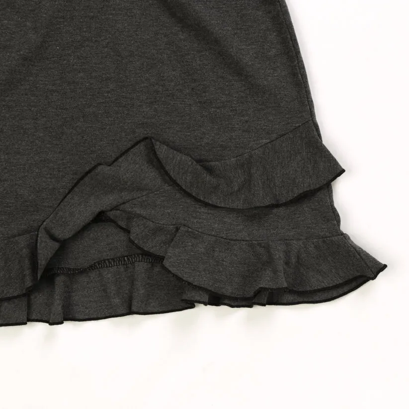 Tight close-up of the ruffle hem showing stitch density on charcoal jersey